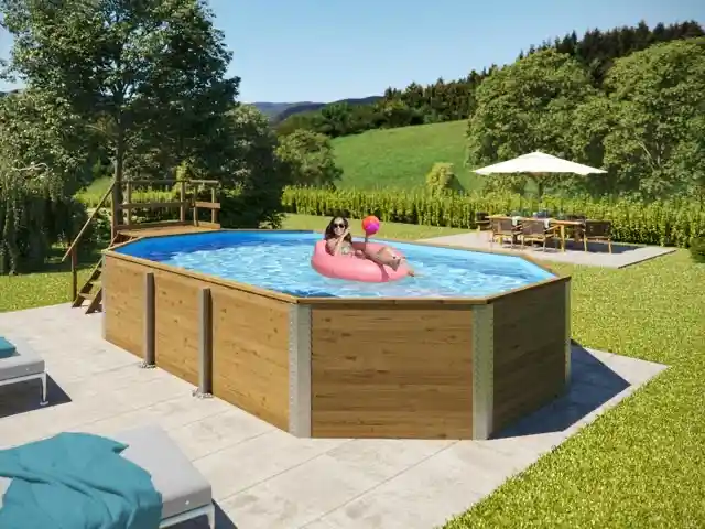 Eine Person liegt auf einem Schwimmring im Pool, umgeben von Garten und Möbeln.