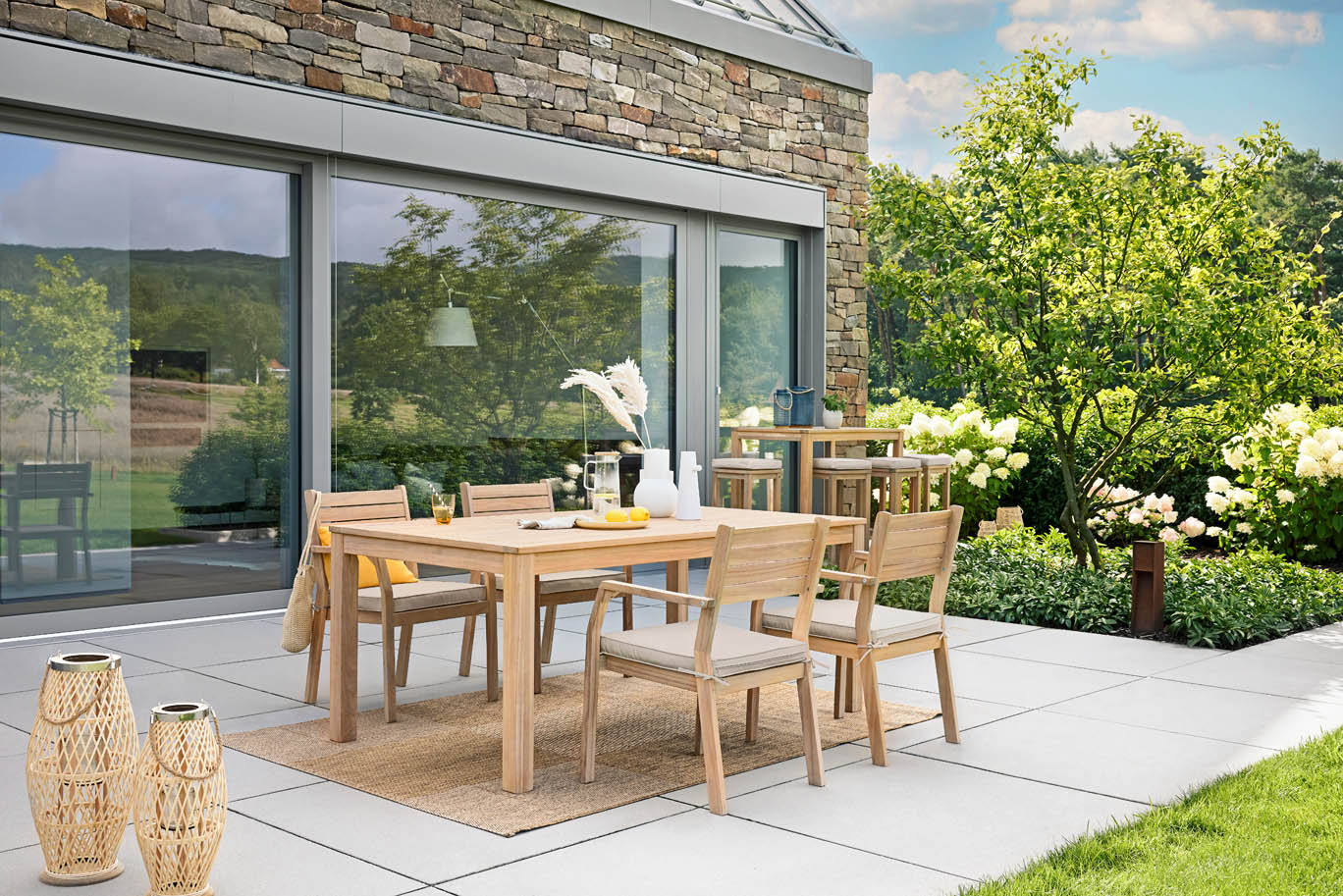 Sitzgruppe auf Terrasse mit Tisch und Stühlen vor Fensterfront