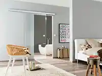 Ein gemütliches Zimmer mit einem Sessel, modernen Möbeln und angrenzendem Bad in stilvollem Ambiente.