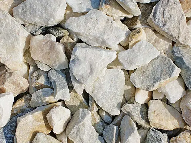 Weiße und beige Steine liegen dicht aneinander auf einer natürlichen Oberfläche.