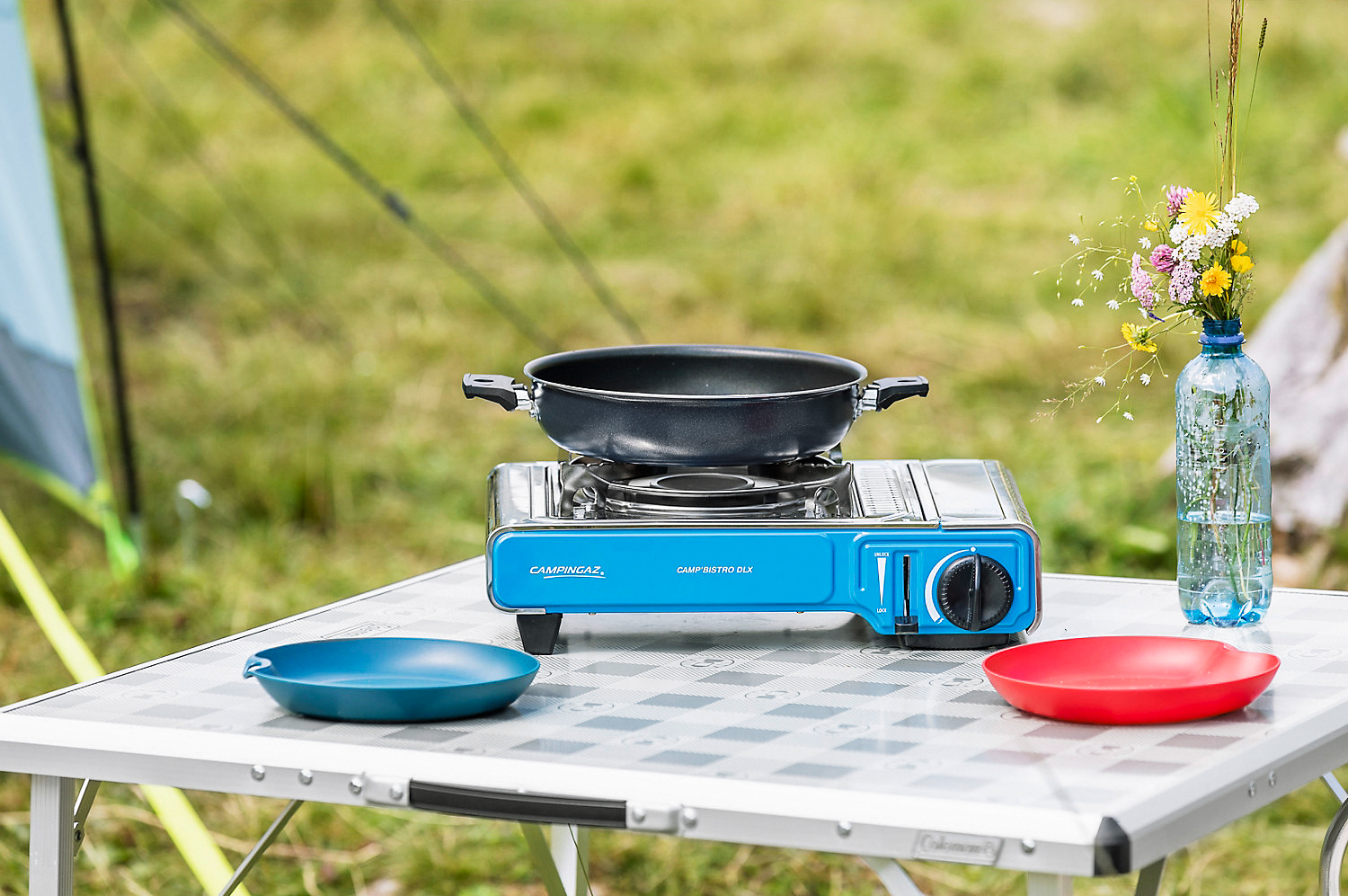 Ein Campingkocher und Geschirr auf einem Campingtisch