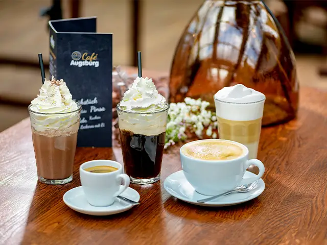Variation an Kaffees auf einem Holztisch serviert im Café Augsburg.