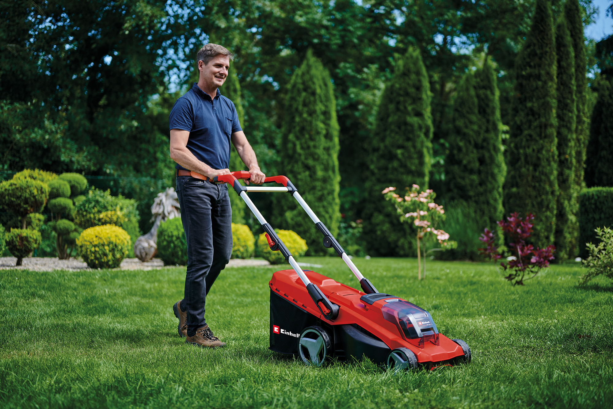 Mann mährt Rasen mit Rasenmäher