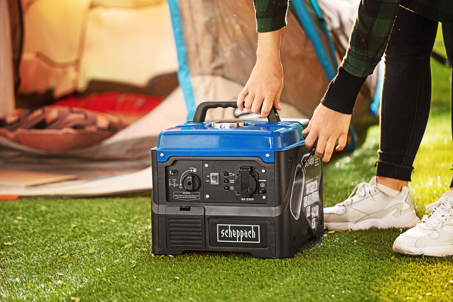 schwarz-blauer Stromgenerator vor Zelteingang