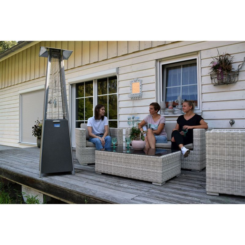 Eine Familie die auf Ihren Gartenmöbeln draußen sitzen und ein Gasheizstrahler der im Vordergrund an ist