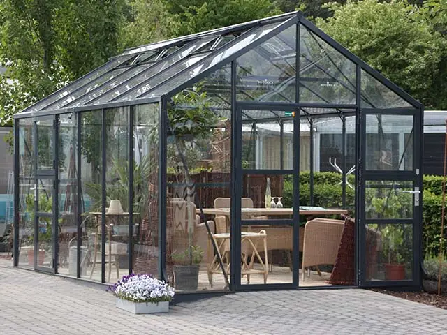 Ein Glashaus steht auf einer gepflasterten Fläche.