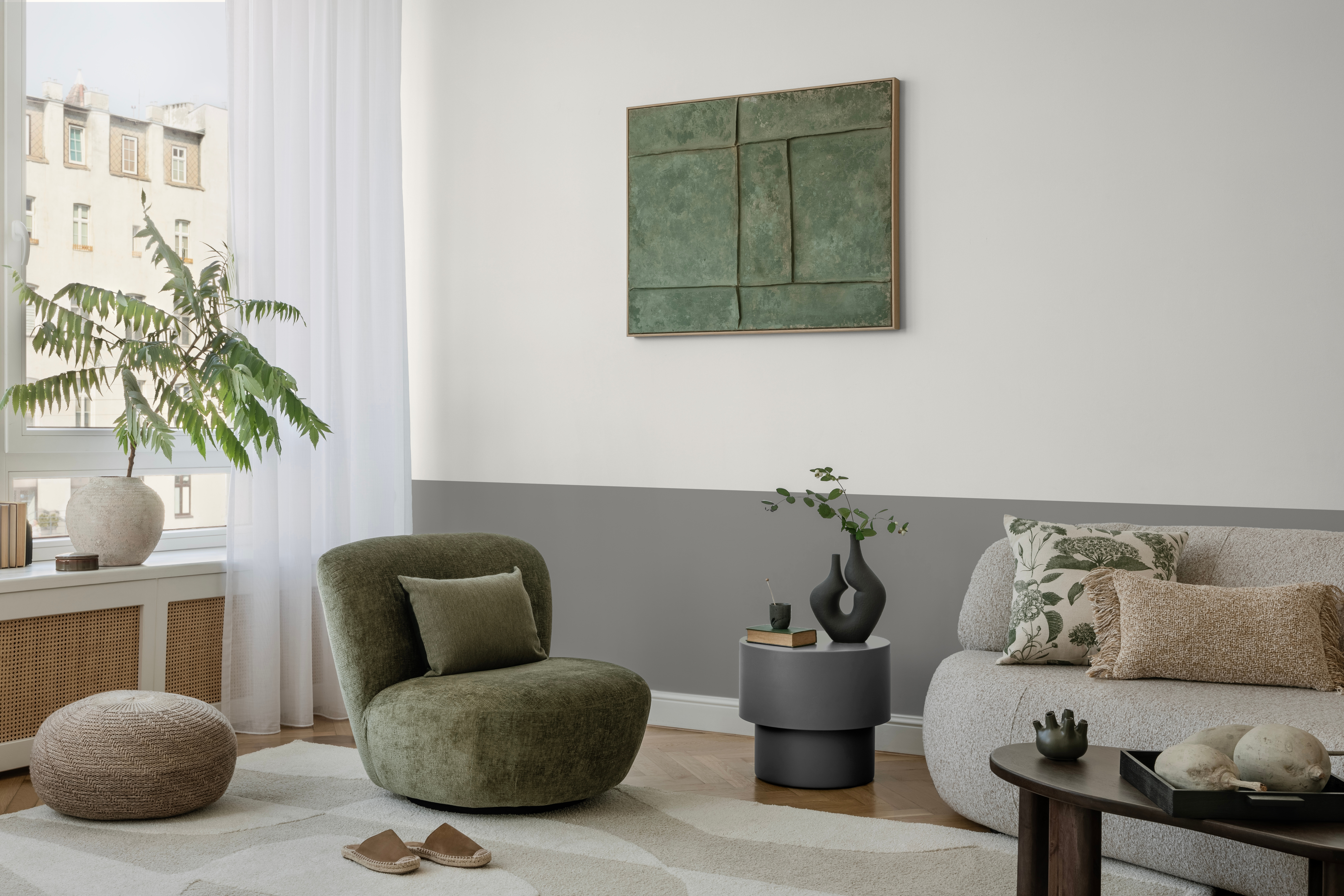 Pastelgrüne Wand mit grünen und grauen Sesseln.