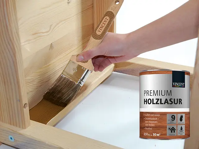Eine Person streicht Holz mit einer Lasur von Vincent.