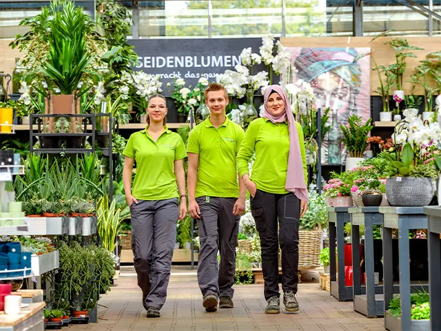 Junge Mitarbeiter stehen in der Pflanzenabteilung vom Gartencenters Augsburg.