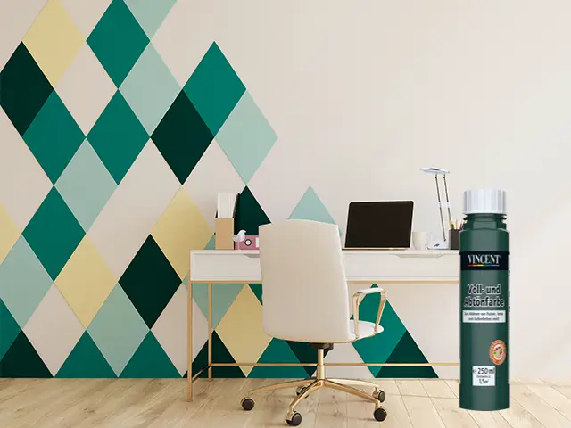 Ein Schreibtischstuhl steht vor einem Schreibtisch mit Laptop, an einer farbenfrohen Wand.