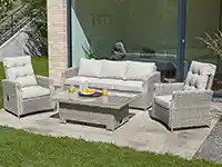 Ein weißes Gartenmöbel-Set steht auf einer Terrasse neben einem Haus, umgeben von grünem Rasen.