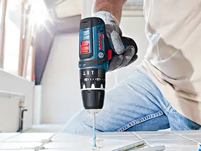 Mann schraubt mit Akku-Schrauber