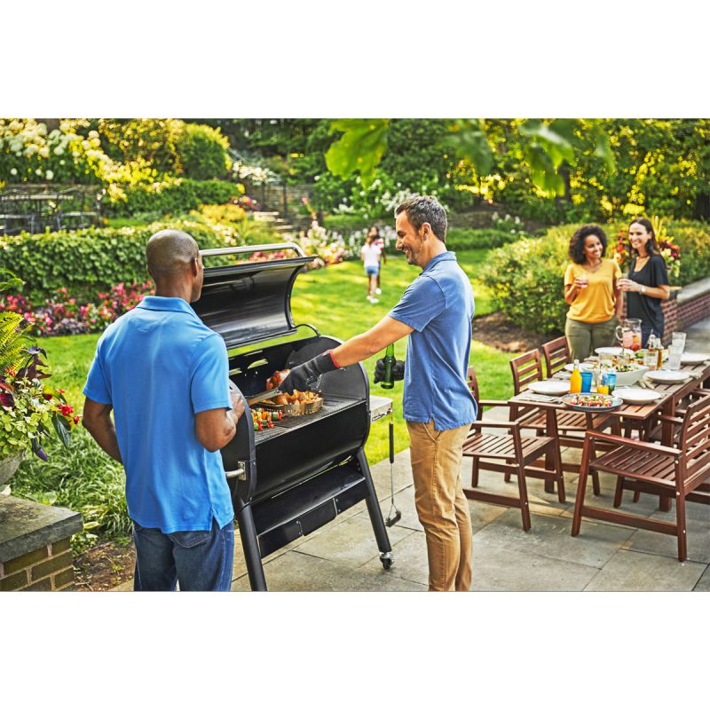 Familie beim Grillen im Garten mit Sitzgruppe
