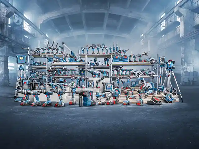 Viele Werkzeuge sind ordentlich in Regalen in einer großen, leeren Fabrikhalle aufgereiht.