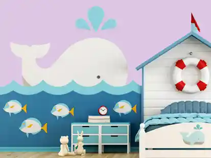 Ein Kinderzimmer mit Wal-Wandbild, Fischen, Spielzeug und einem Bett im maritimen Stil.

