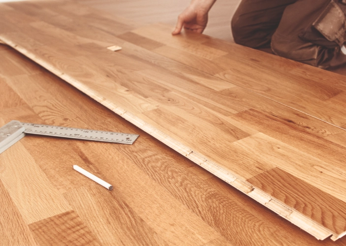 Handwerker verlegt Laminat und passt ein Paneel an