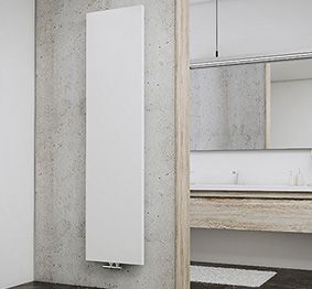 Ein weißer, vertikaler Heizkörper hängt an einer grauen Betonwand in einem modernen Badezimmer.