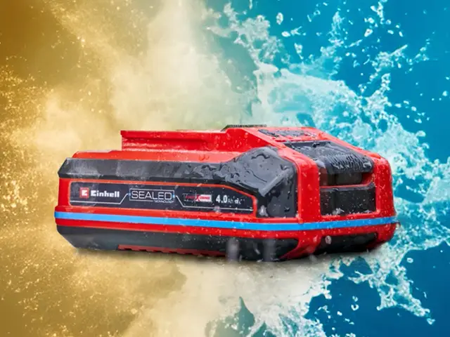 Ein roter Einhell-Akku mit Wasserspritzern im Hintergrund.