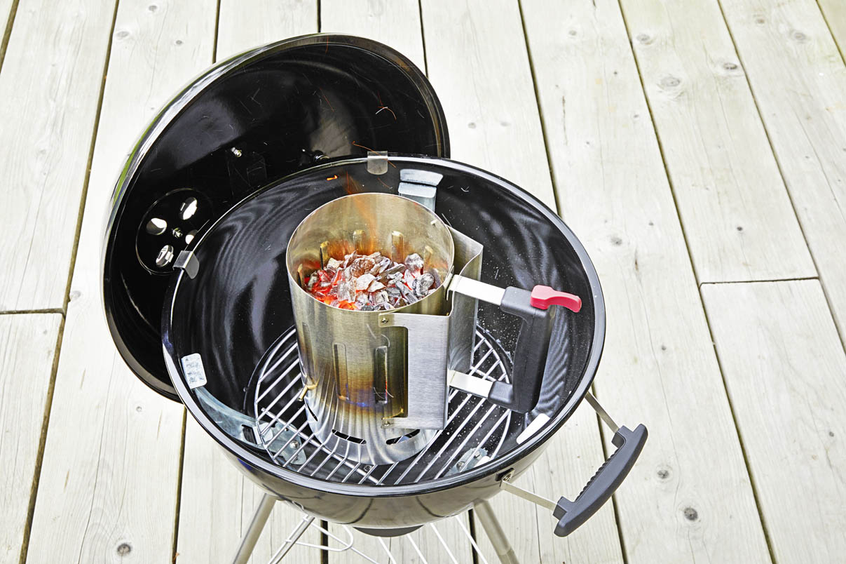 Ein Anzündkamin im Grill in der die Kohle gerade glüht