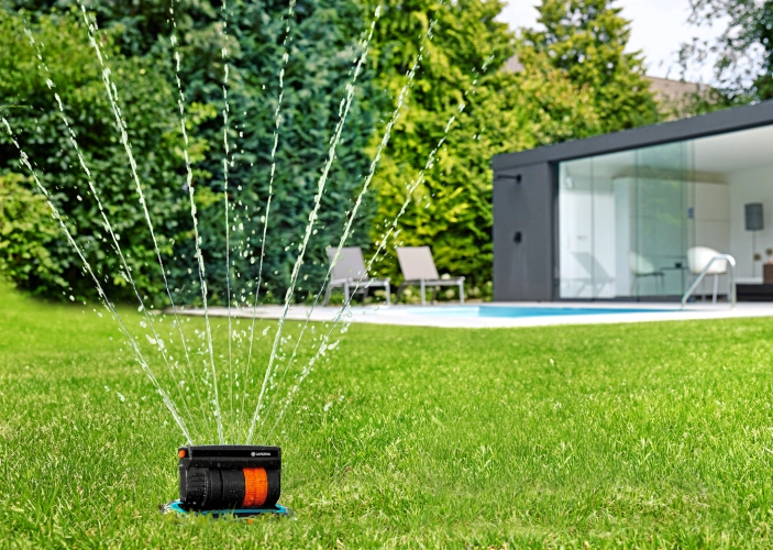 Rasensprenger in einem Garten im Sommer, Gartenbewässerung
