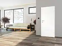 Ein weißer Türrahmen steht in einem modernen Wohnzimmer mit Holzfußboden und großen Fenstern.