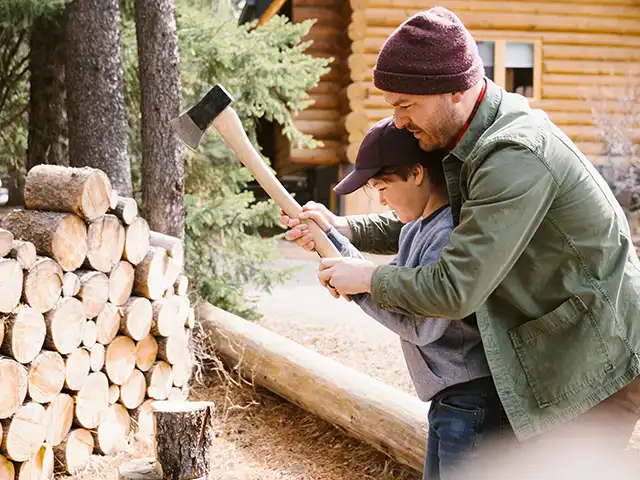 Mann macht Brennholz mit Kind