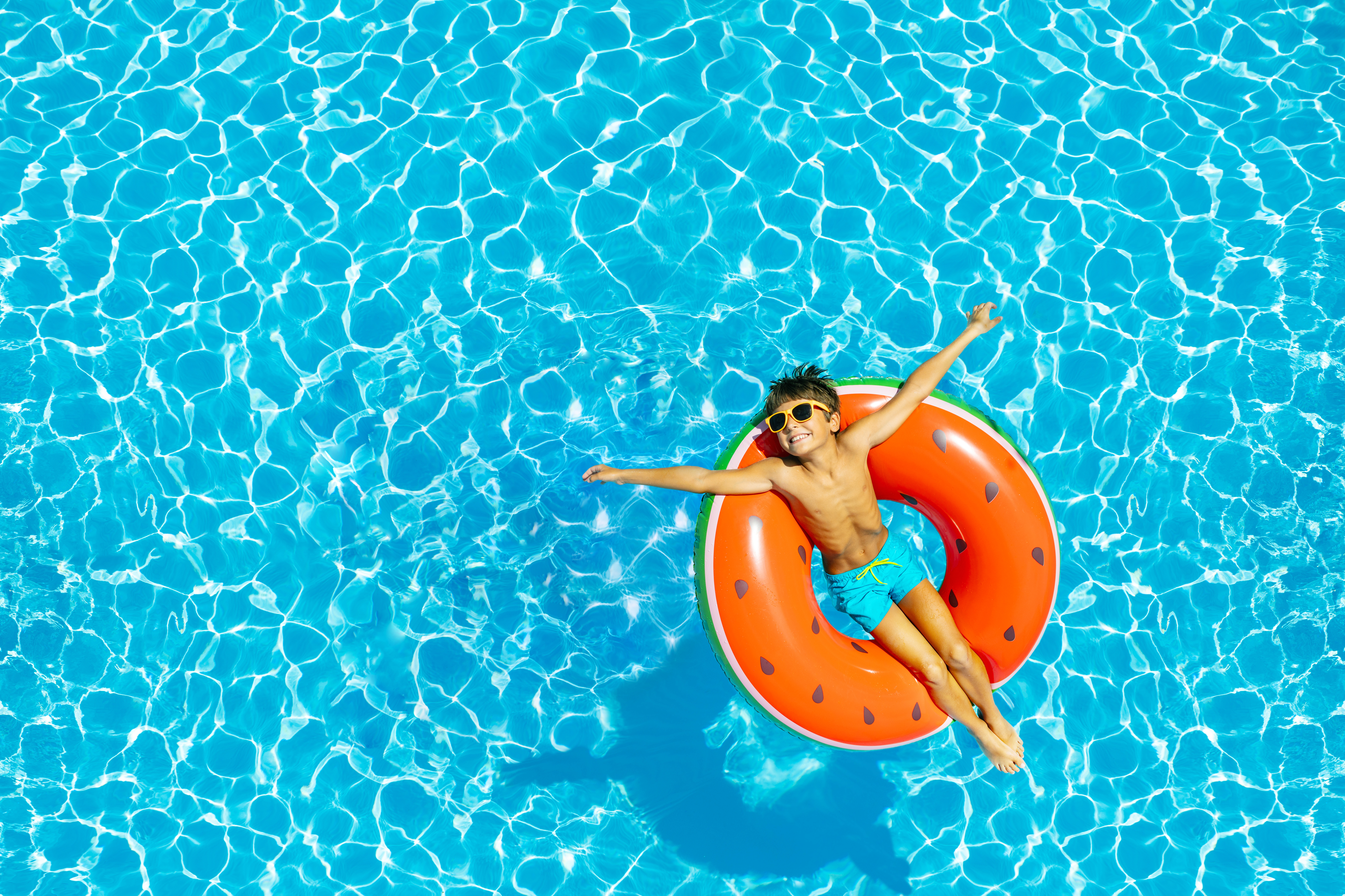 Ein Junge liegt in einem Schwimmreifen in einem Pool.