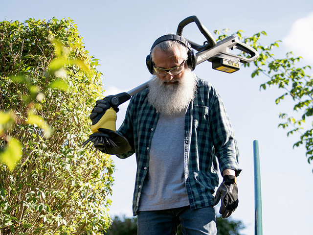 Mann mit Gehörschutz und Kärcher Gartenwerkzeug