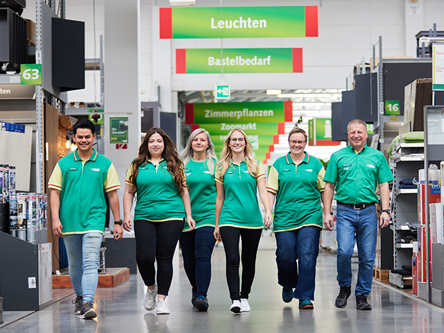 Eine Gruppe von BayWa-Mitarbeitern läuft durch den Baumarkt.