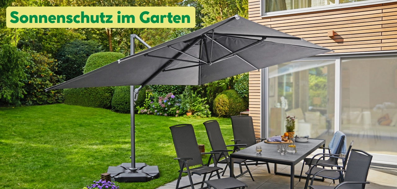 Grauer Ampelschirm über einer Sitzgruppe in einem Garten