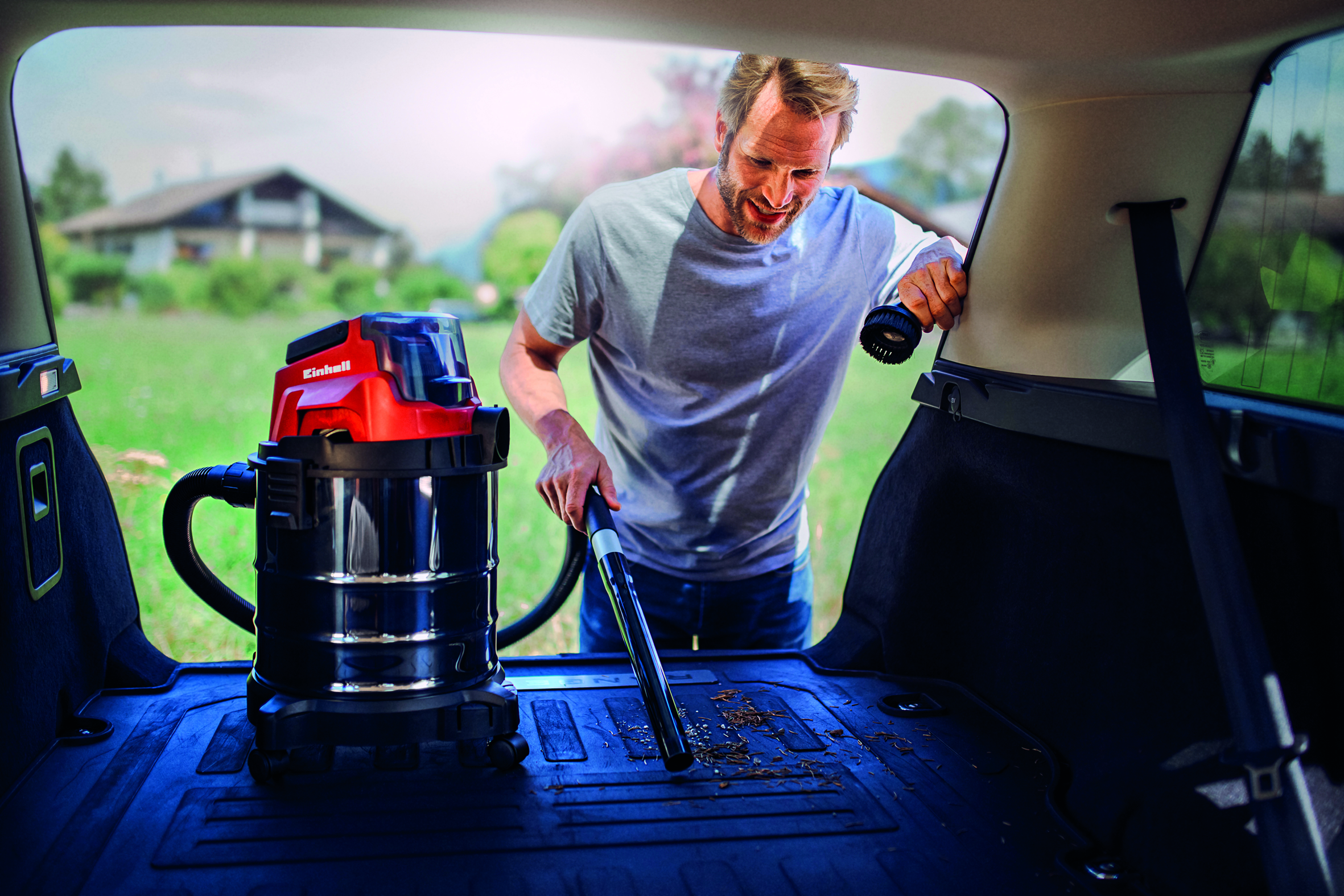Mann saugt Auto mit Industriestaubsauger aus