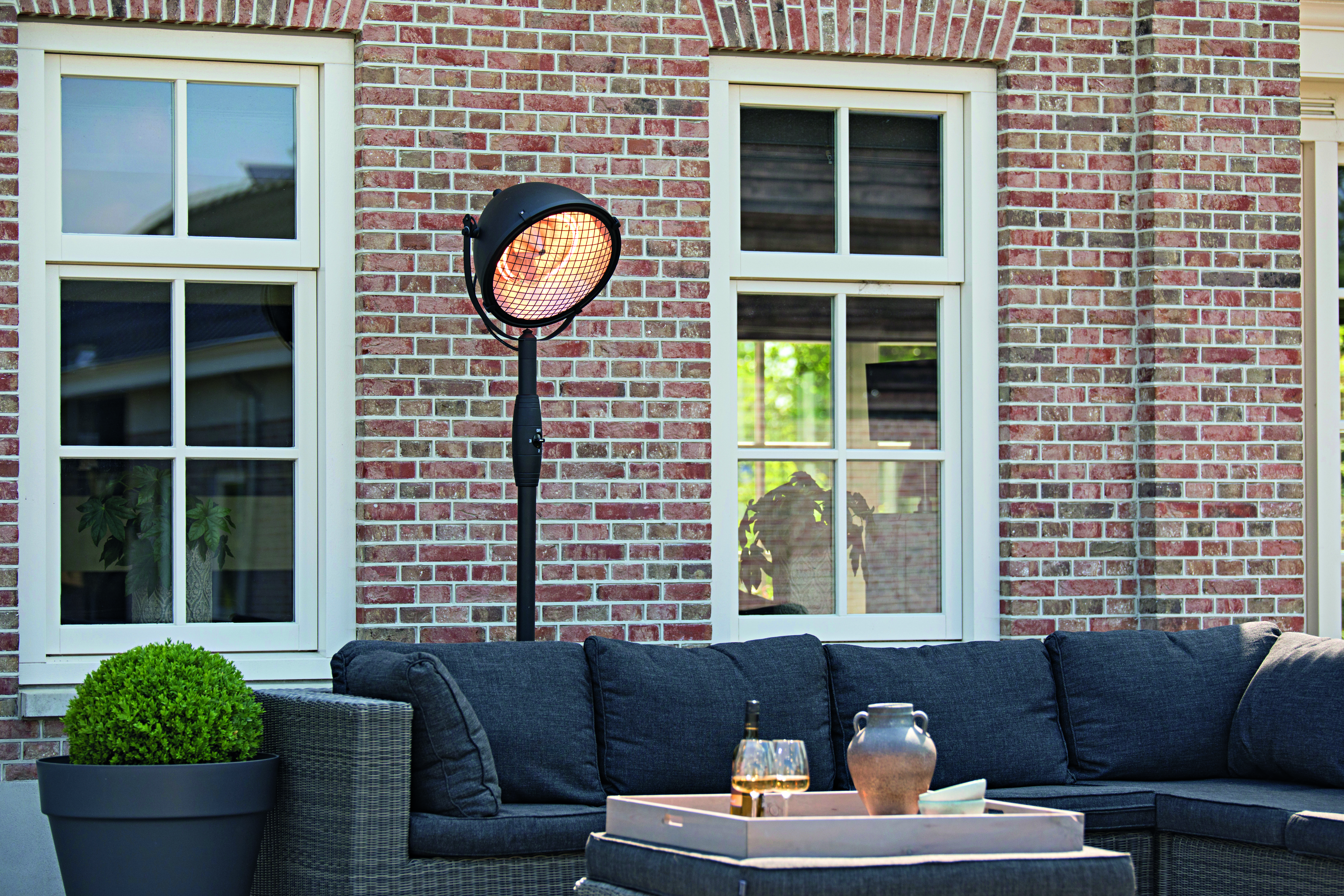 Ein Heizstrahler der hinter einer Gartenmöbel Sitzgruppe steht