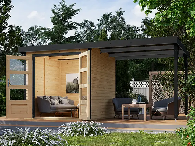 Eine Holzhütte mit offener Veranda und Möbeln steht in einem grünen Garten.