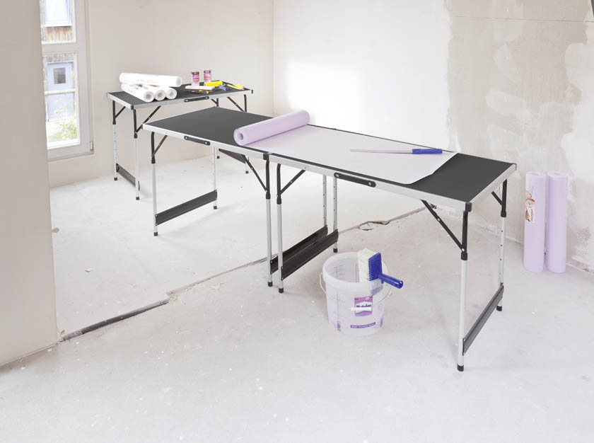 Ein Tapeziertisch mit Utensilien der mitten im Raum steht