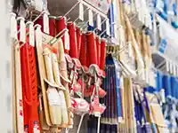 Verschiedene Pinsel zum Malen hängen ordentlich an einem Metallgestell.