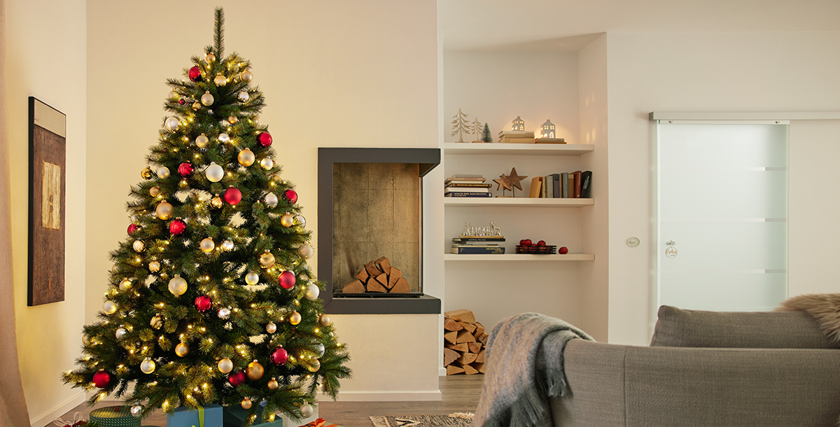 Künstlicher, geschmückter Weihnachtsbaum in einem Wohnzimmer